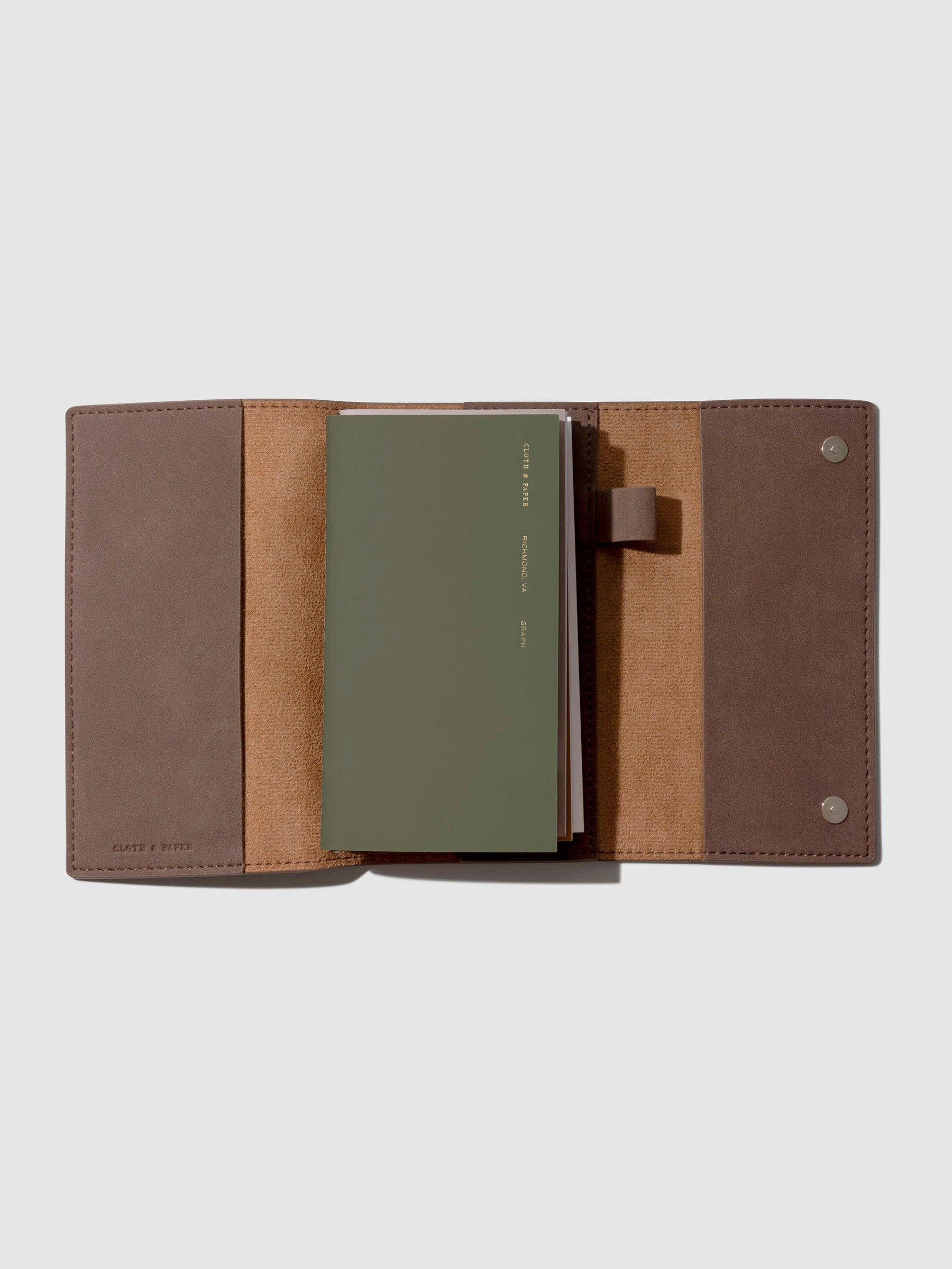 Notebook cover displayed open with a Travel Notebook inside it on a neutral background.