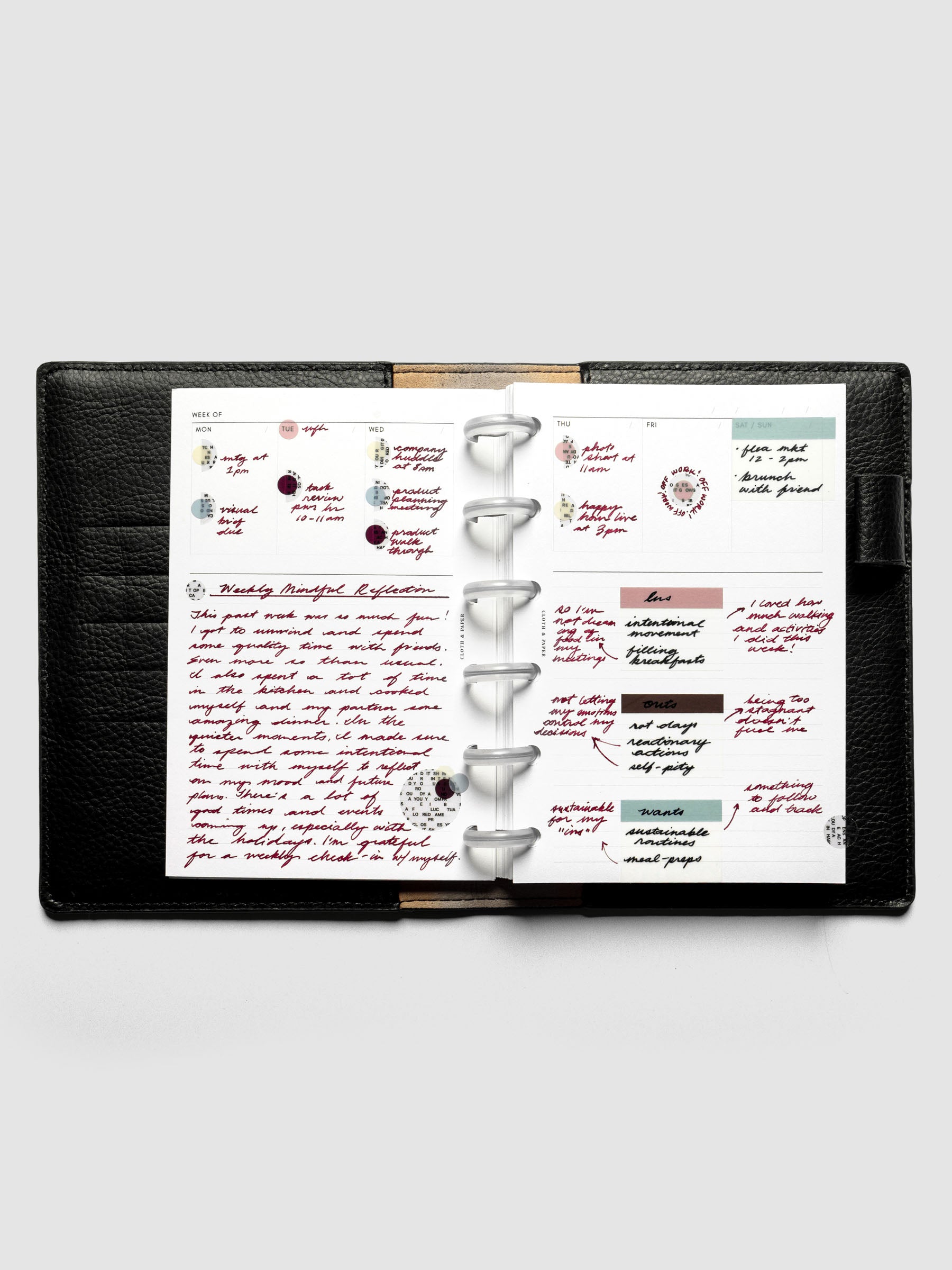 CP Petite Undated Weekly Notes Planner Inserts ringbound in a black leather folio with handwritten notes, page flags, and stickers.