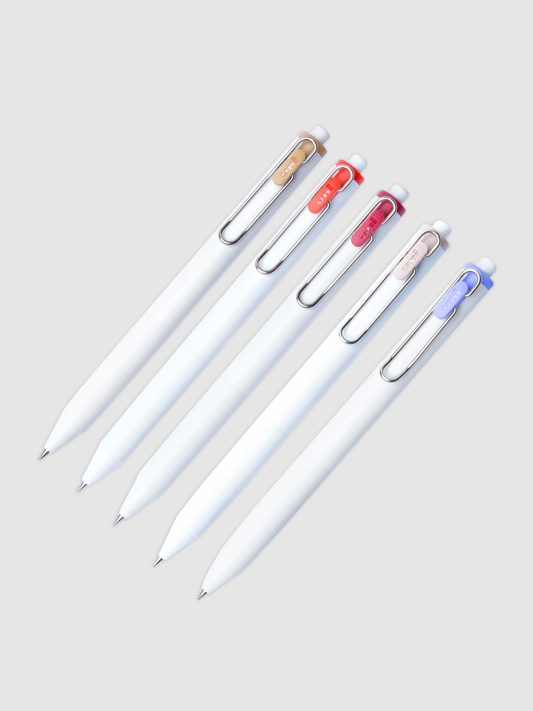 5 Uni-ball One Gel Pens with 0.38 mm nibs arranged parallel to each other. All are turned to the right against a neutral background.