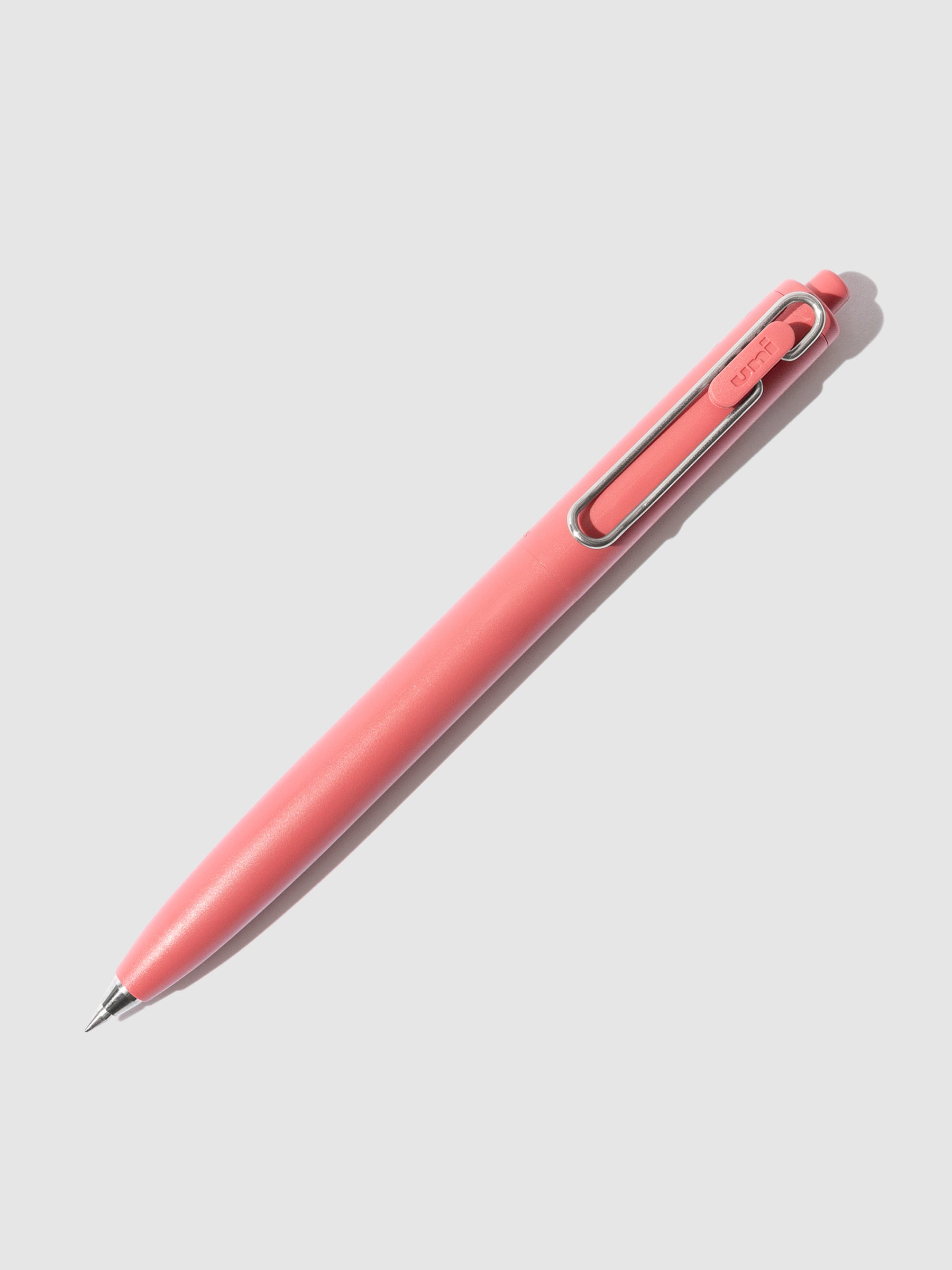 Red pen turned to the right against a neutral background.