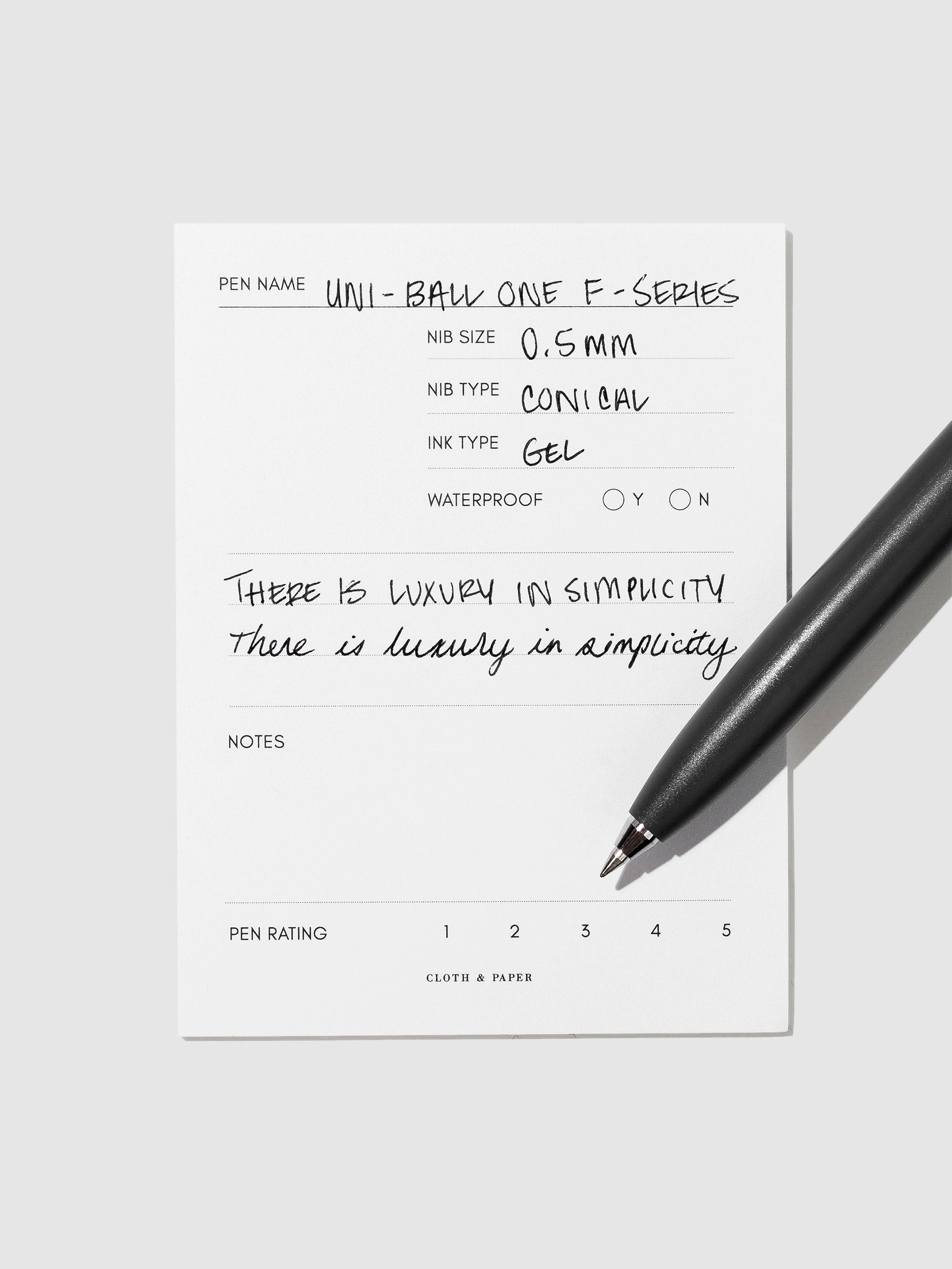 Dark Grey pen resting on an in use pen test sheet.