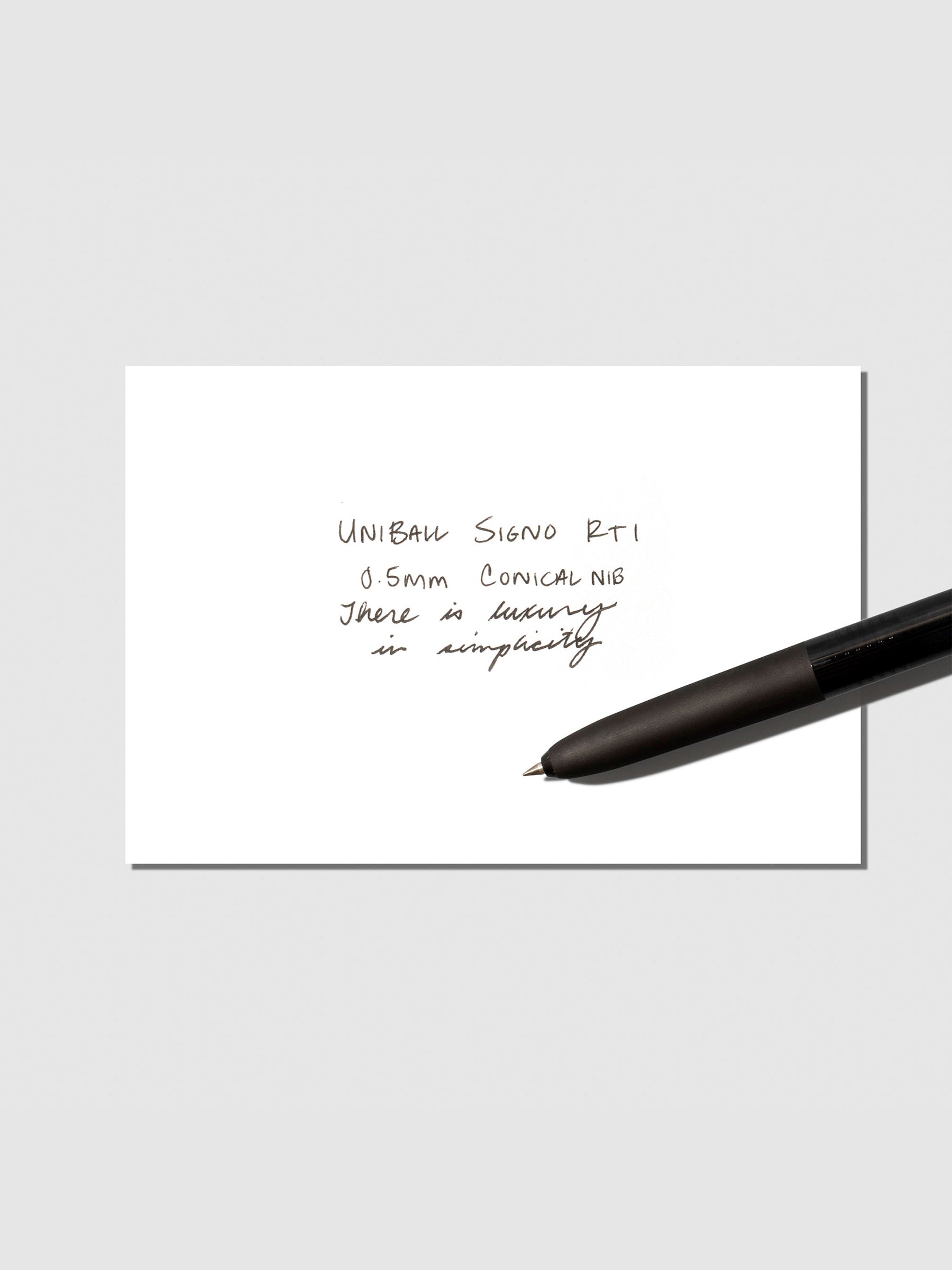 Uni Ball Signo displayed with writing sample on a neutral background.