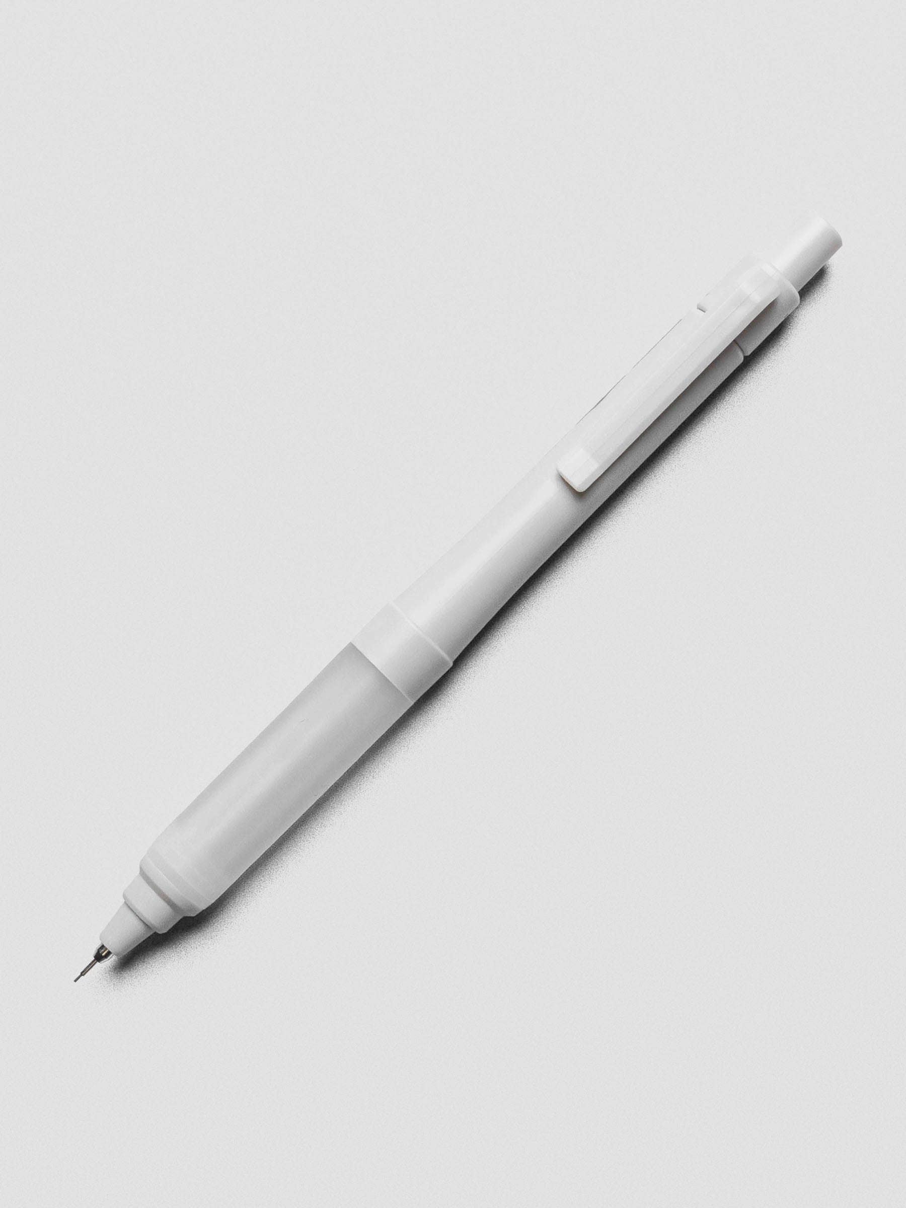 Grey mechanical pencil on a grey background.