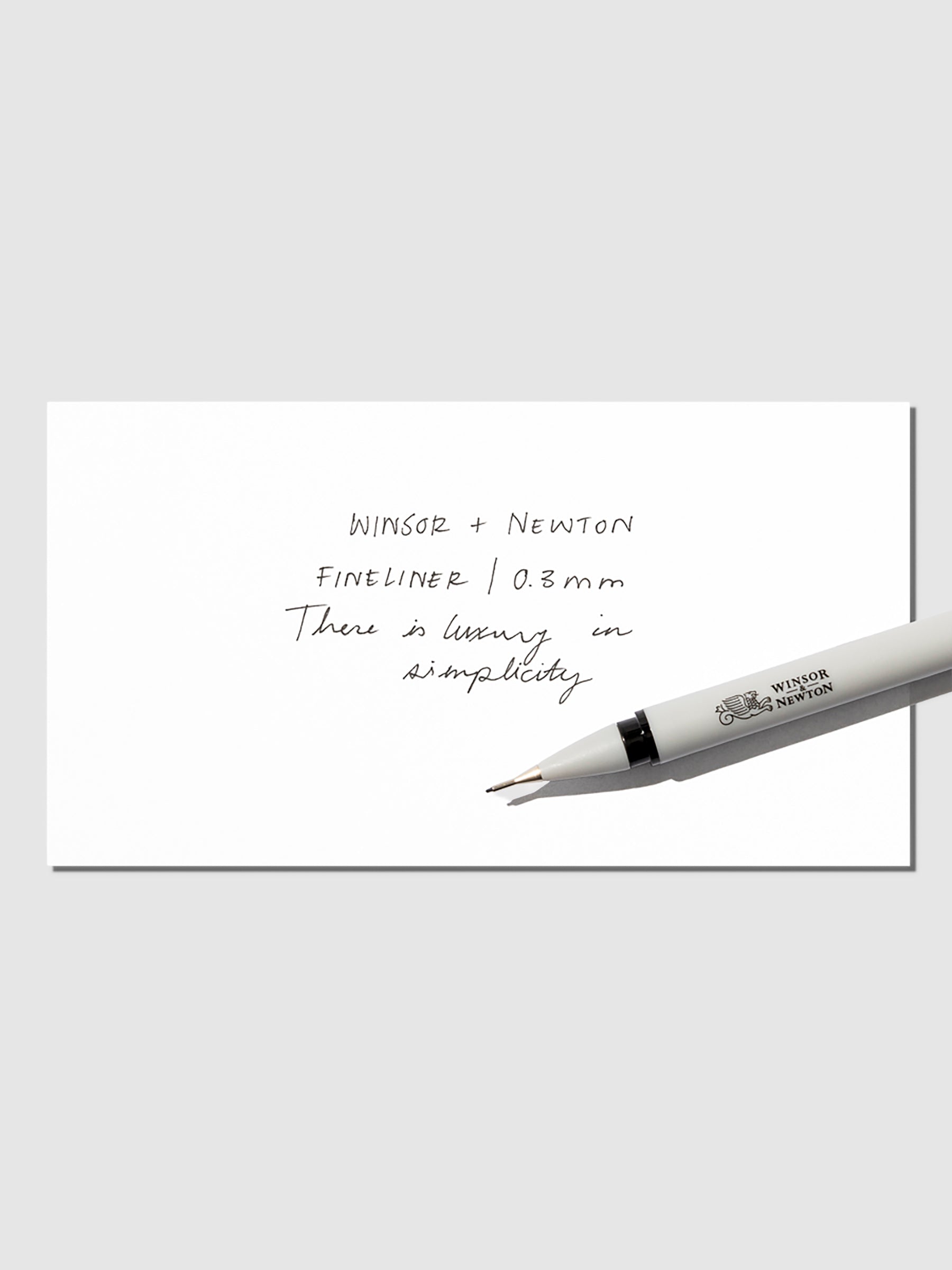 Pen displayed with writing sample on a neutral background.