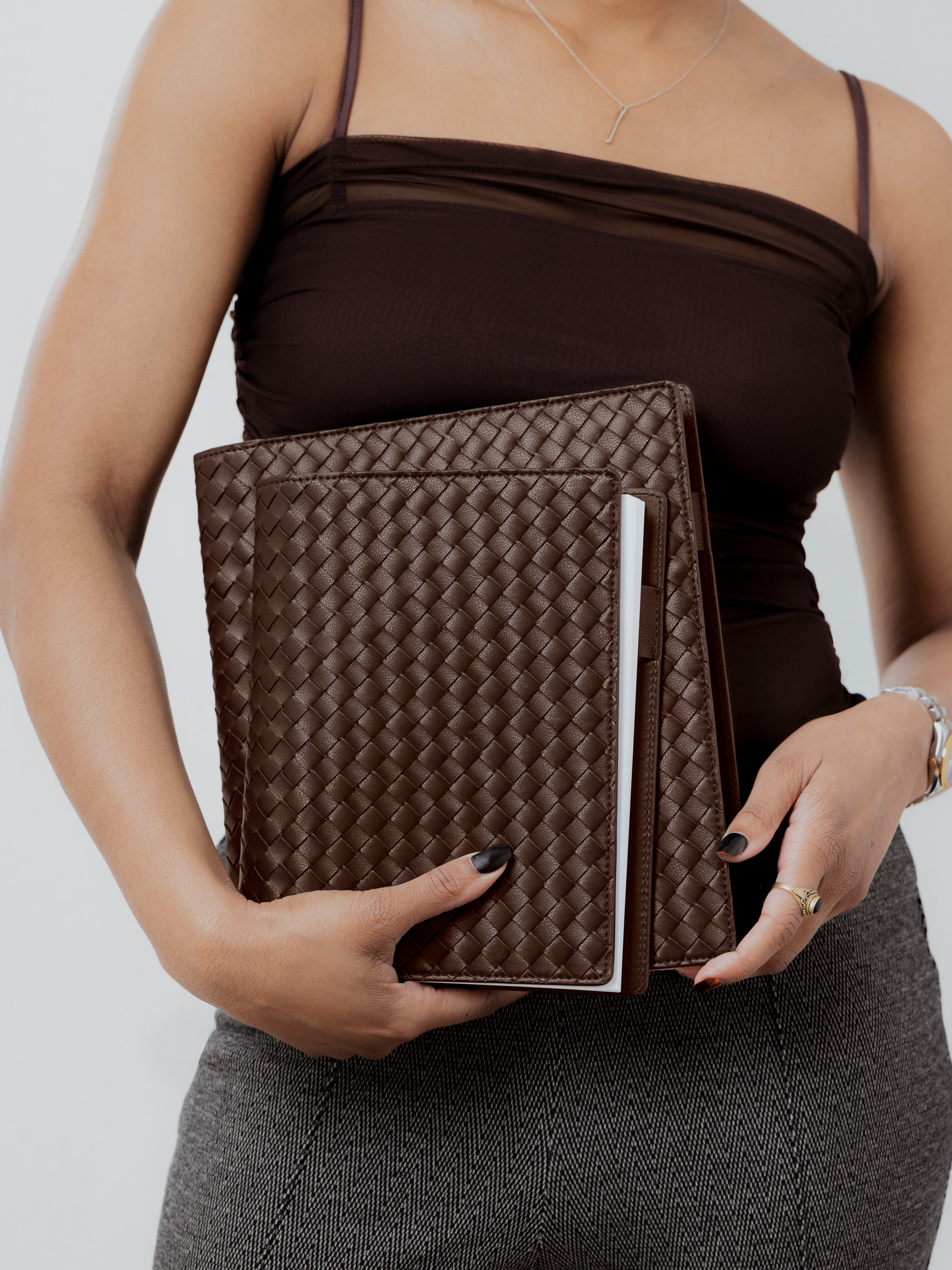 Woman holding a large and HP Classic sized woven planner cover.