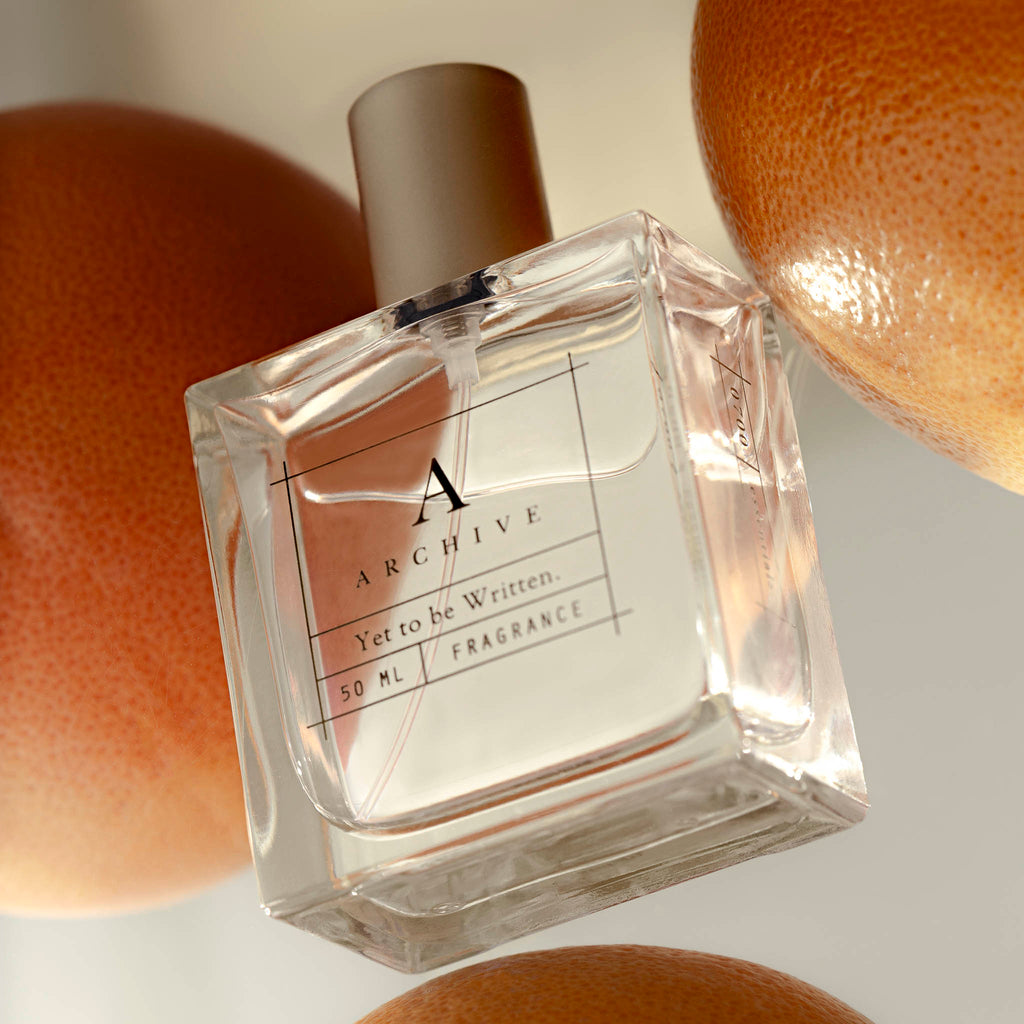 A spoiler image from our Aesthete Box for Spring 2024.  The Yet to be Written Perfume is seemingly floating with citrus surrounding it.