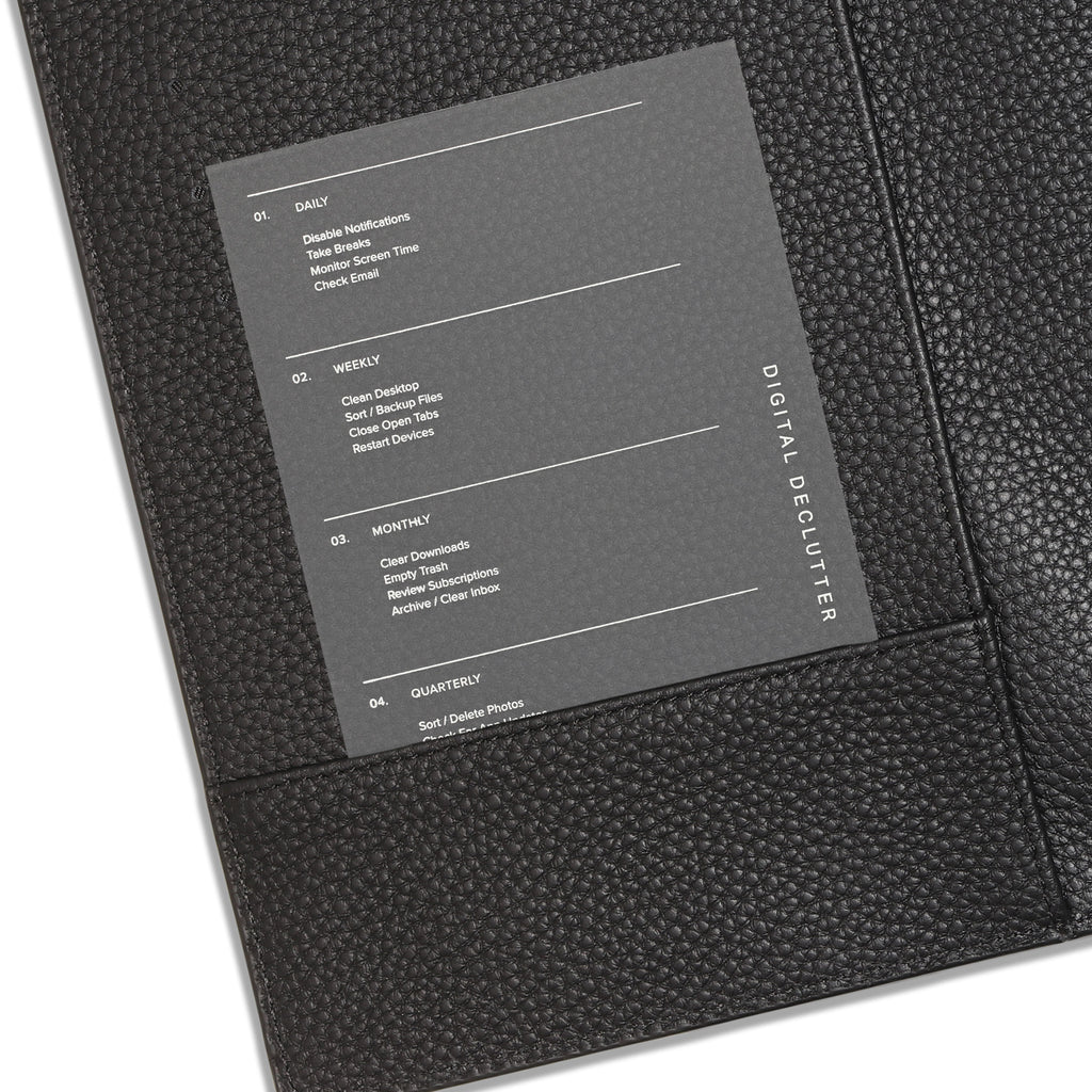 Journaling card inserted into the pocket of a black smooth leather planner cover.