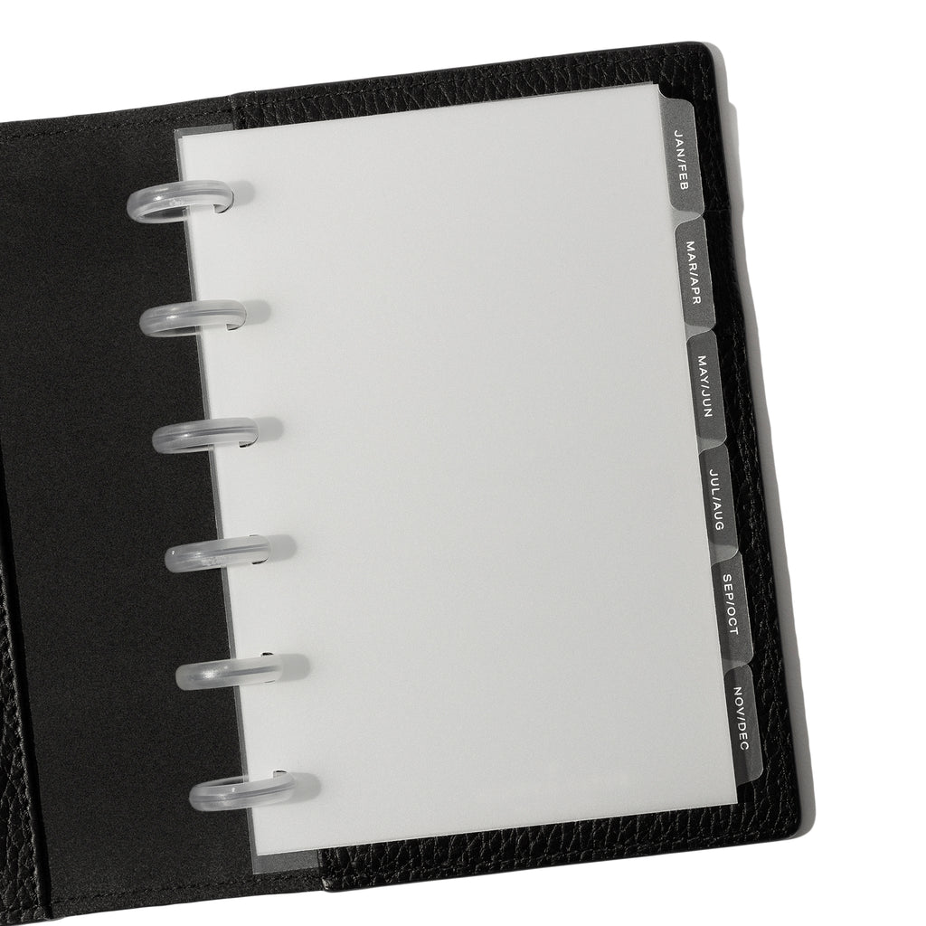 White foil tabs displayed in use inside a black leather folio.
