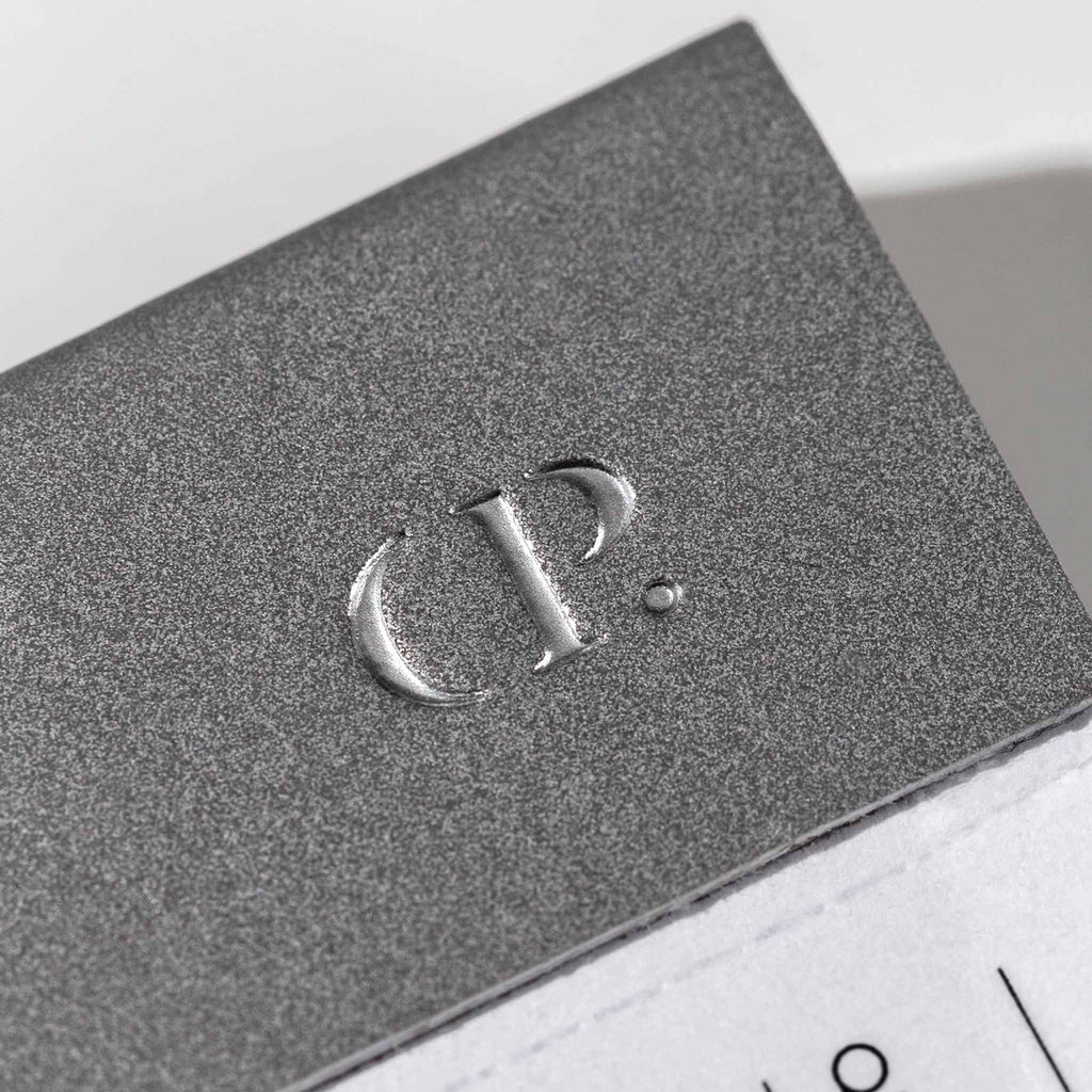 Closeup of Cloth and Paper CP logo embossed on the notepad's spine.