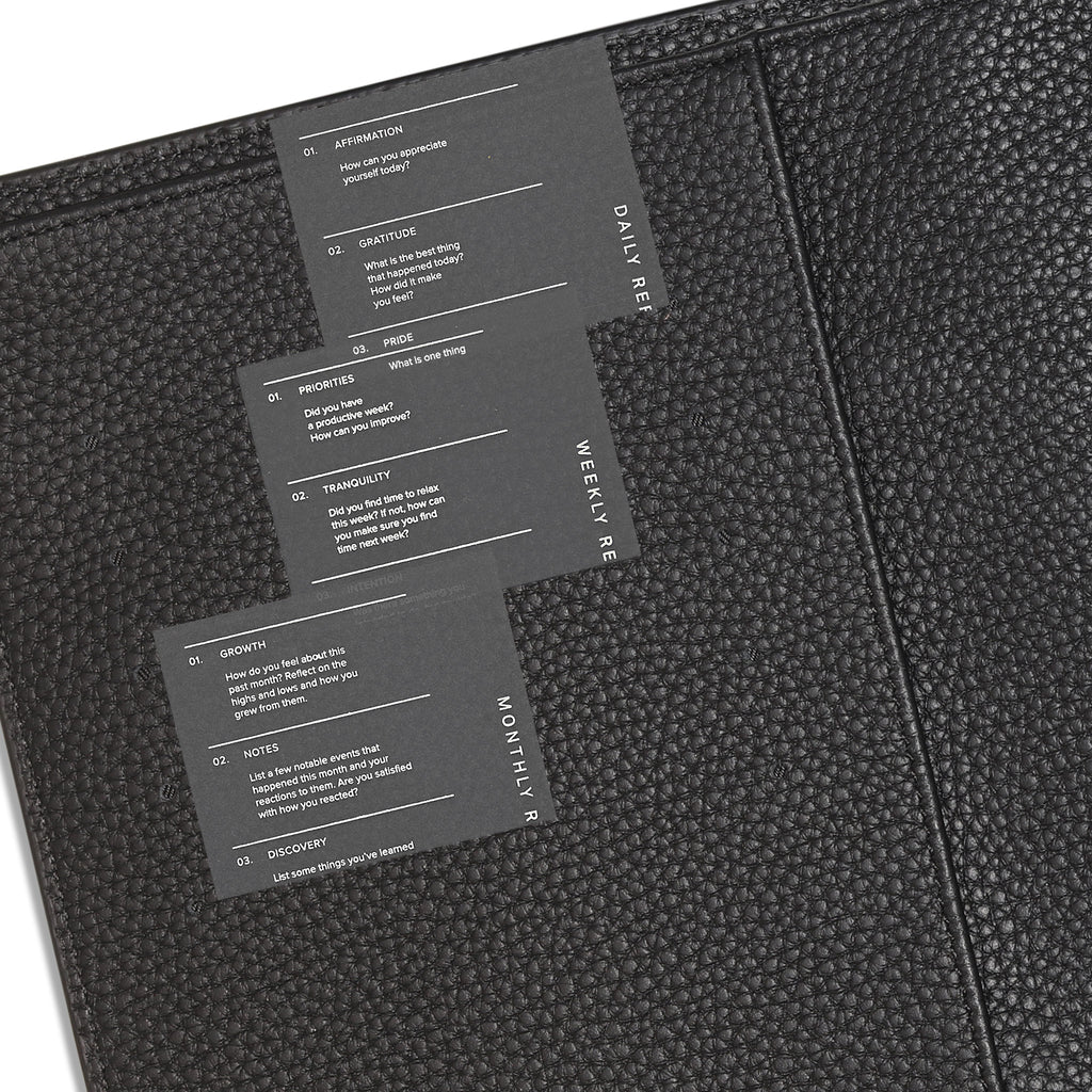 Set of 3 journaling cards tucked into the pockets of a smooth black planner cover