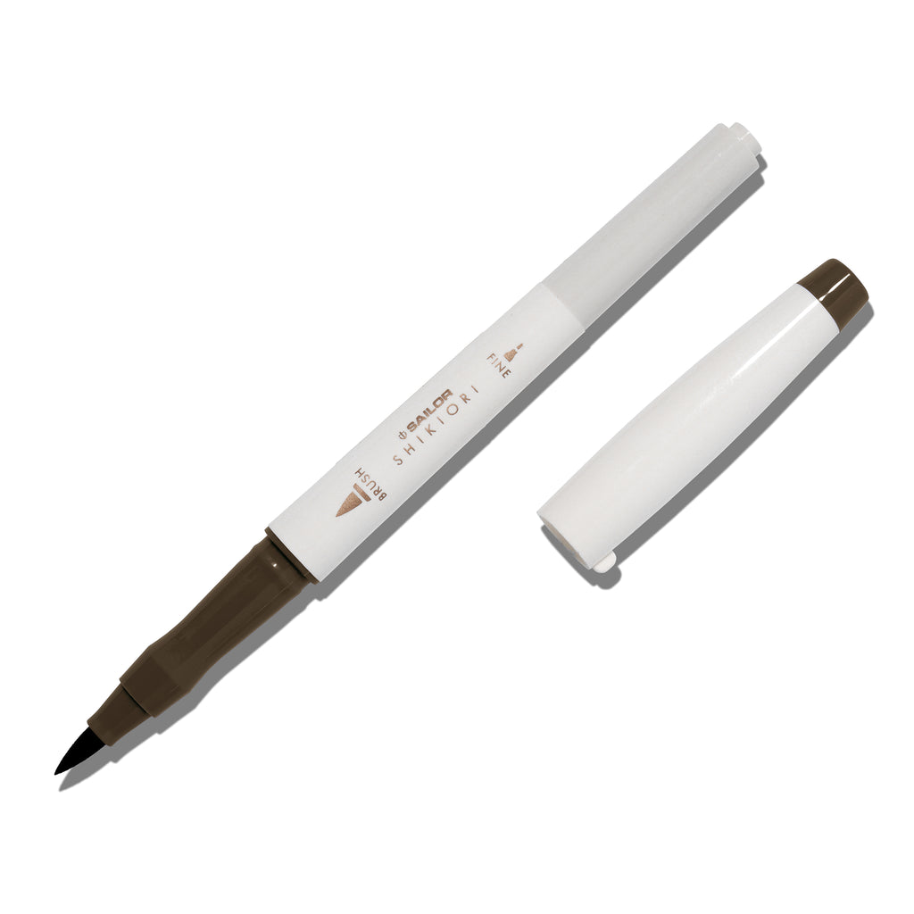 Brush pen displayed on a white background. It is uncapped with its brush nib exposed, and the cap lying parallel to the marker. Color pictured is Doyou. 