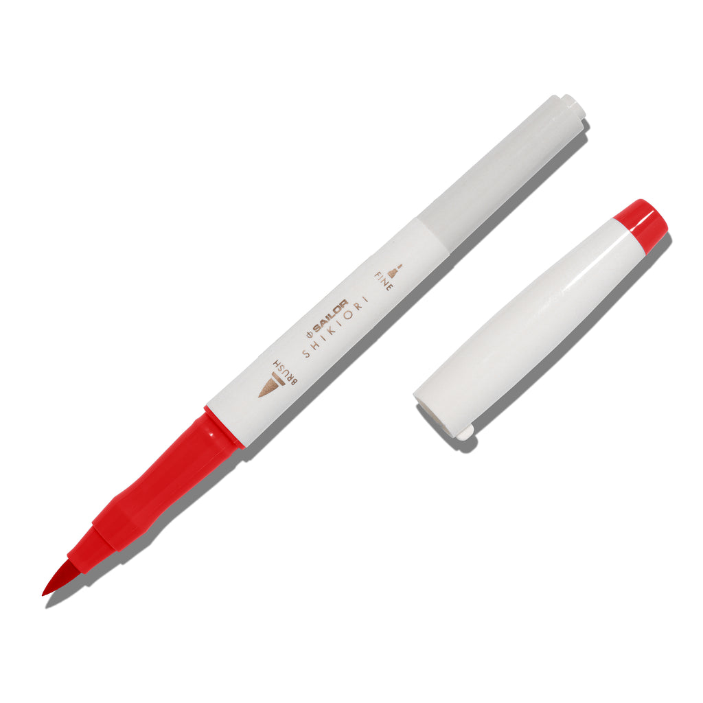 Brush pen displayed on a white background. It is uncapped with its brush nib exposed, and the cap lying parallel to the marker. Color pictured is Irori. 