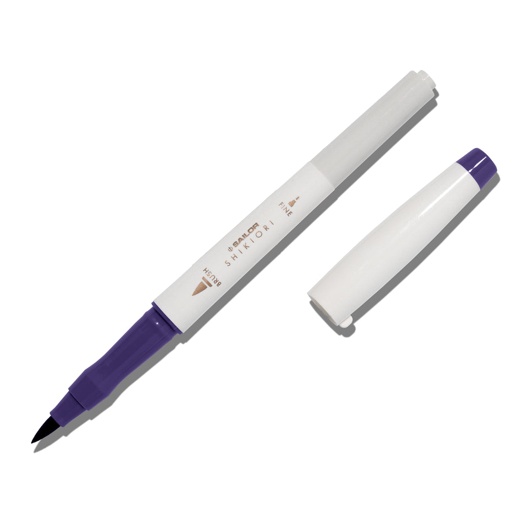 Brush pen displayed on a white background. It is uncapped with its brush nib exposed, and the cap lying parallel to the marker. Color pictured is Shigure. 