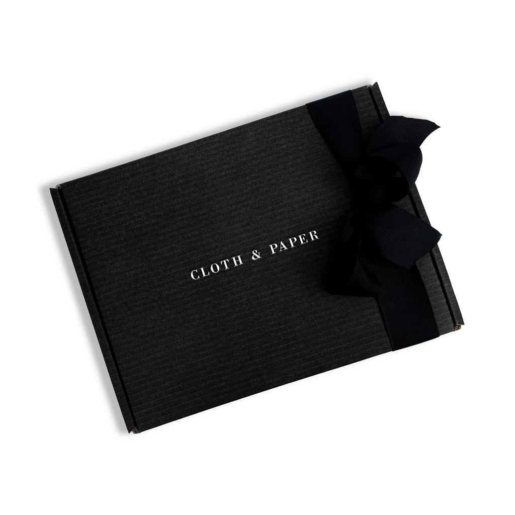 Stationery Mystery Box, Cloth and Paper. Cloth and Paper box adorned with a black bow displayed on a white background.