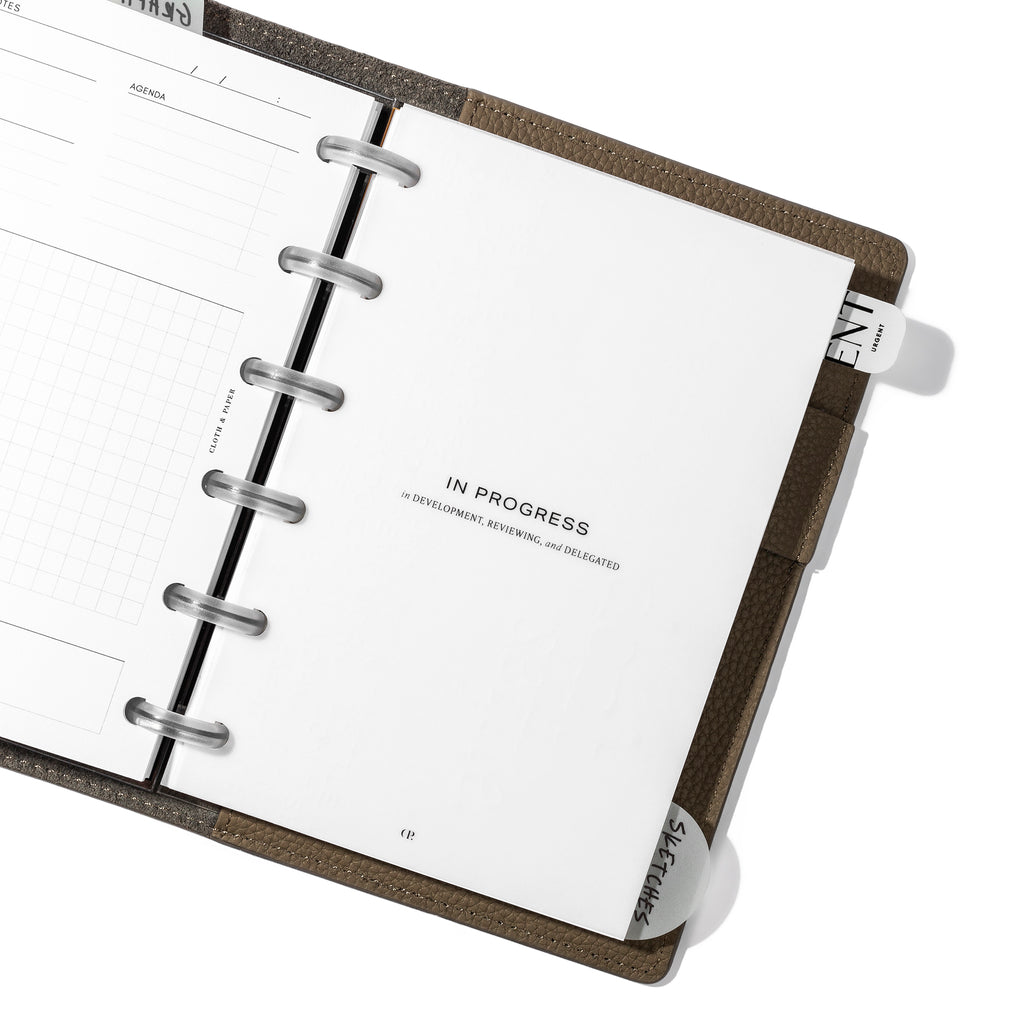 "In Progress" dashboard in use inside a leather planner cover.