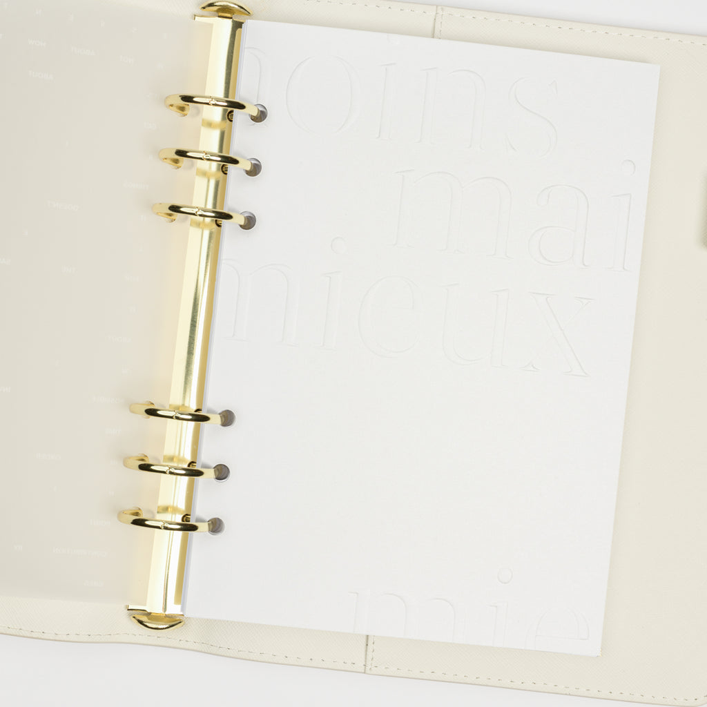 Dashboard duo in use inside a white leather planner. Dashboard displayed is opaque white with embossed text.