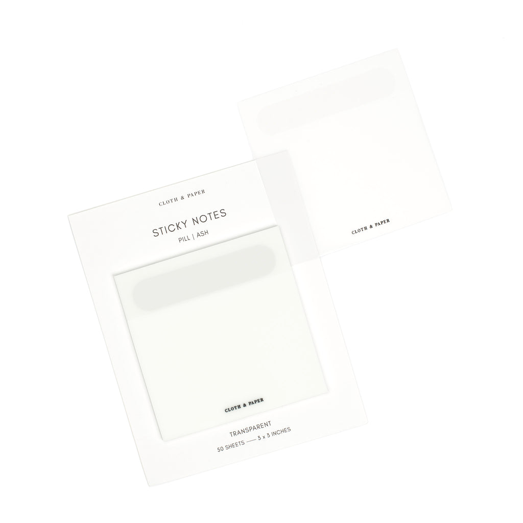 Ash sticky notes on their backing displayed on a white background. One note is removed and placed on the edge of the backing to display its transparency.