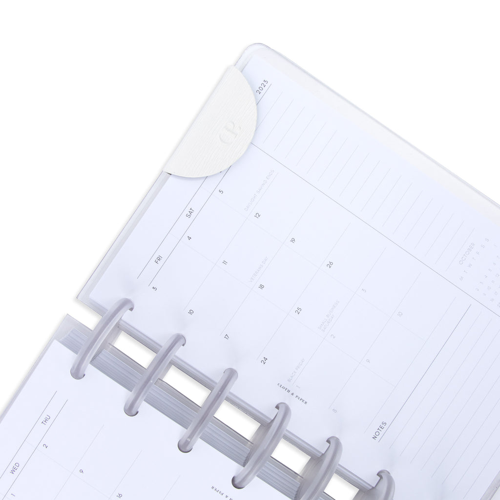 White bookmark in use inside a discbound planner system.