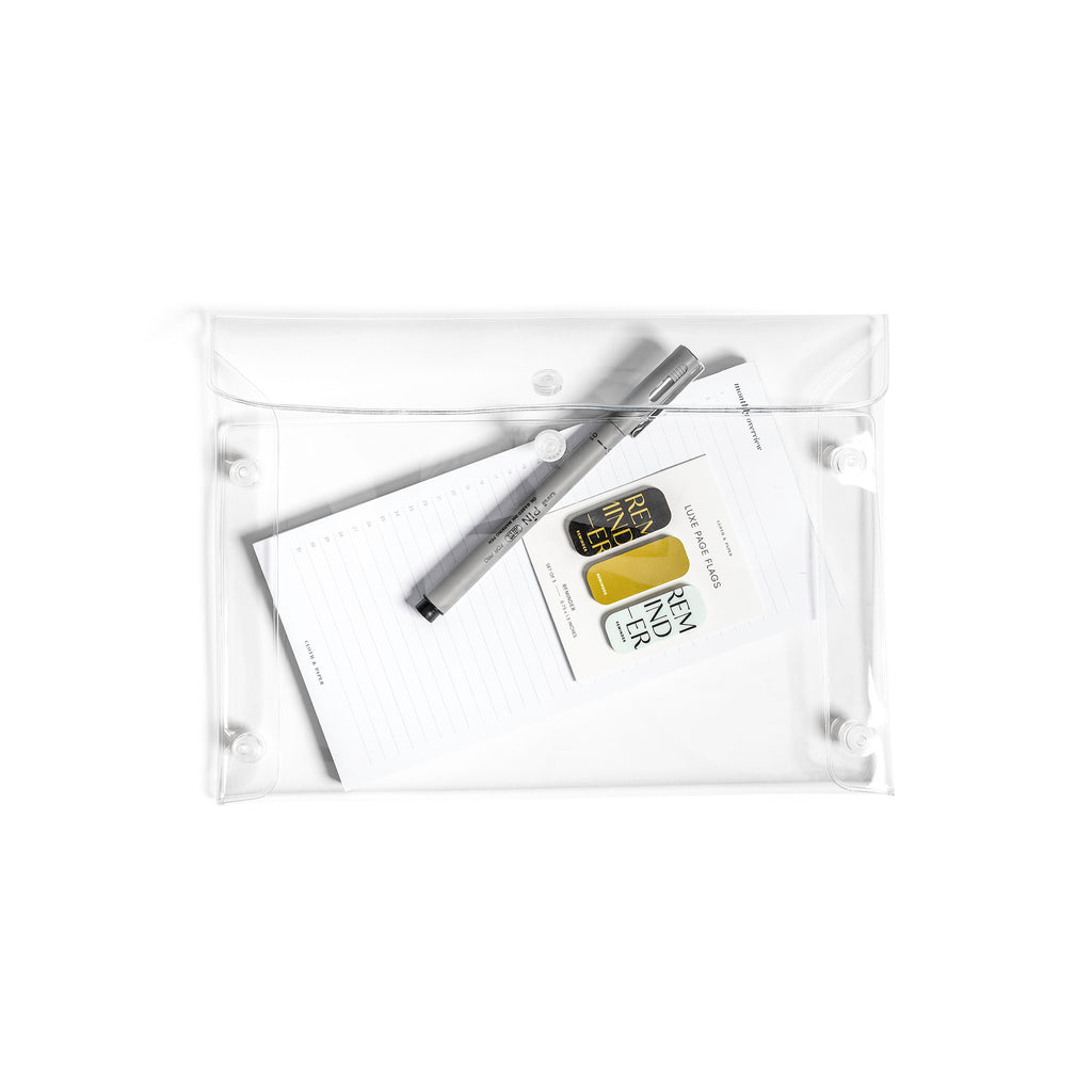 Pouch displayed filled with accessories on a white background. The items in the pouch are a Uni Pin Marking Pen, Monthly Overview Notepad, and Reminder Luxe Page Flags.