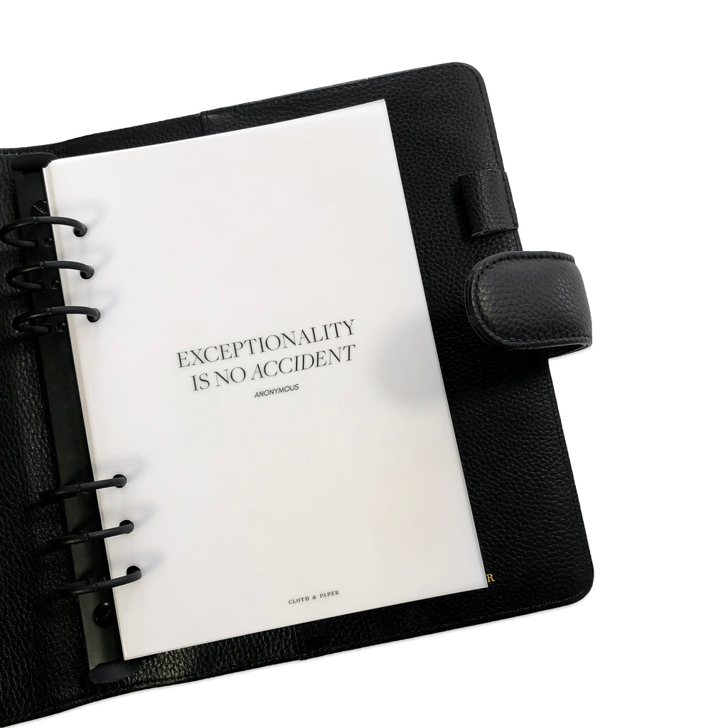 Exceptionality Dashboard, Cloth & Paper, A5. Vellum dashboard in use inside of a black leather planner with black rings on a white background.