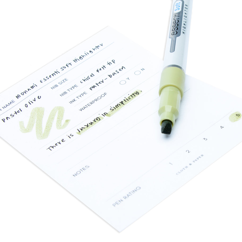 Close up on the felt nib of the Pastel Olive highlighter resting on a pen test sheet displaying a writing sample.