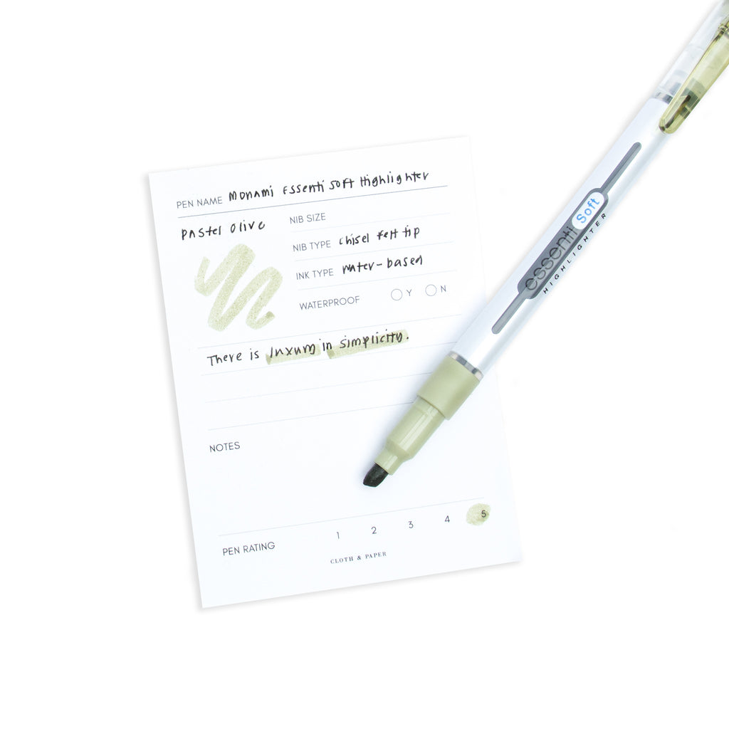 Pastel Olive highlighter resting on a pen test sheet displaying a writing sample detailing the highlighter's specs.