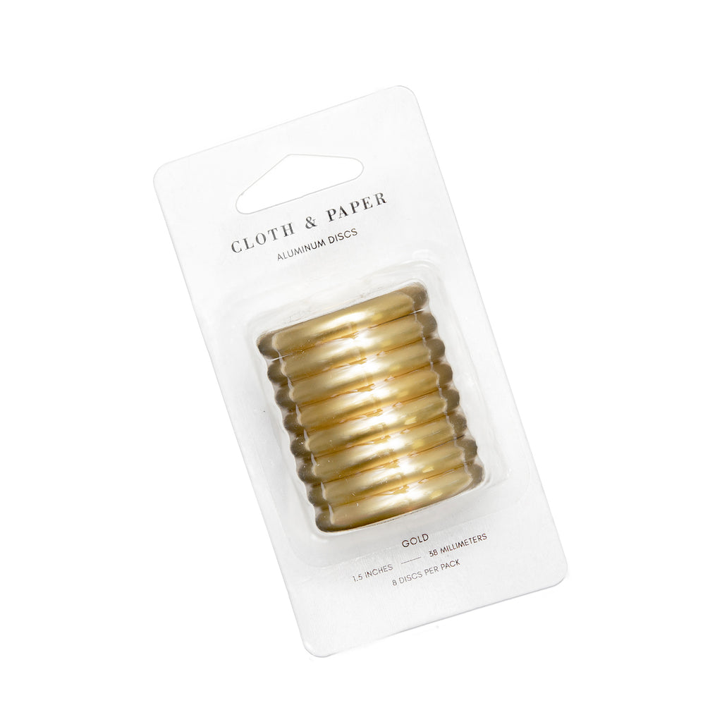 Planner Discs made from Gold Aluminum with a 1.5 inch diameter inside their blister pack, turned to the left against a white background.