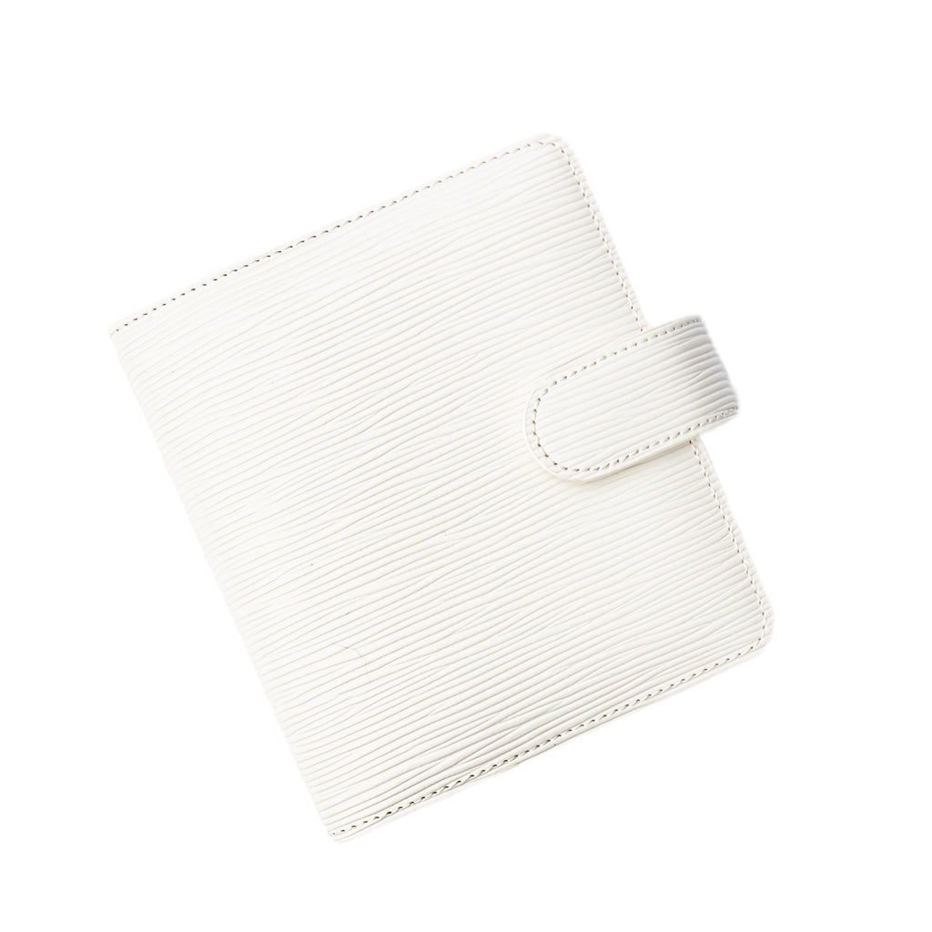 6-Ring Agenda in Pocket Size with White Contoured Leather closed to show the front cover. The agenda is turned to the left against a white background.