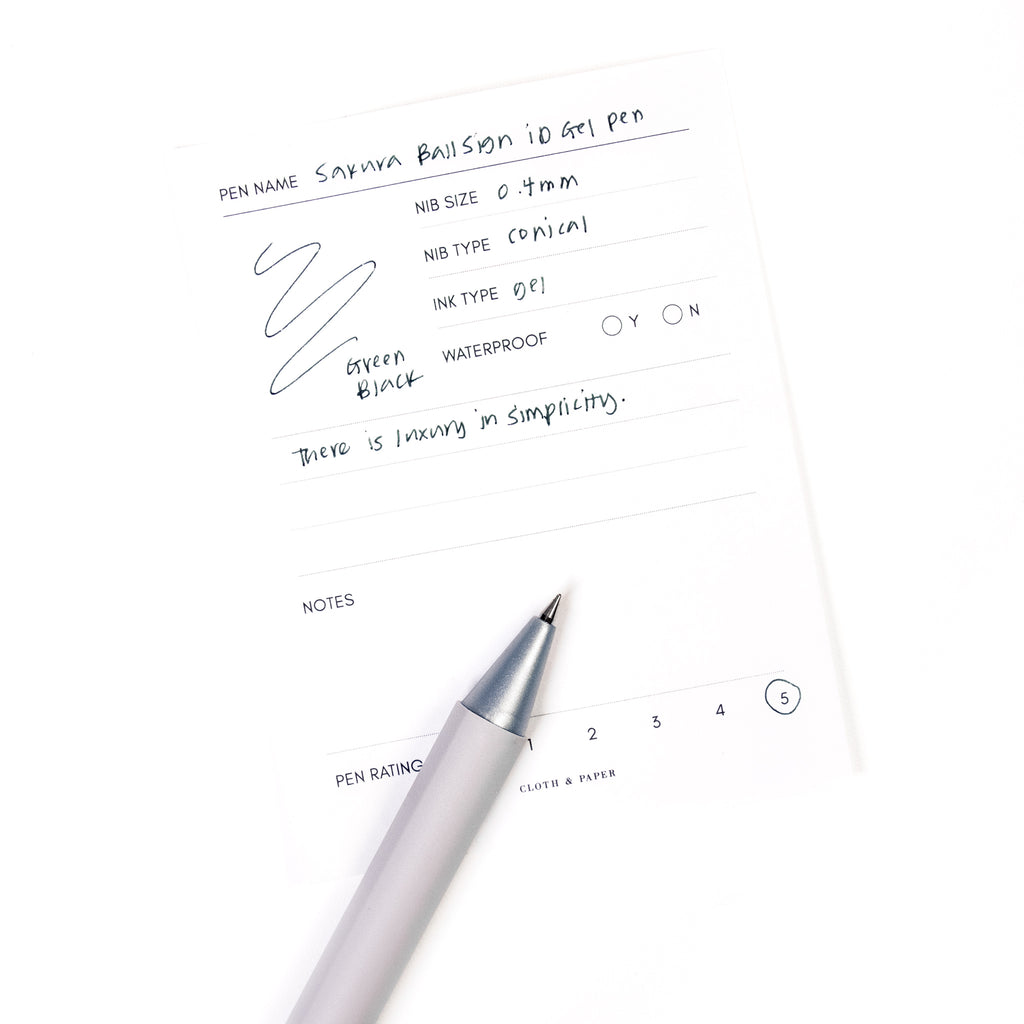 Sakura Ballsign iD Gel Pen, 0.4 mm, Cloth and Paper. Green black pen resting on pen test sheet displaying writing sample.