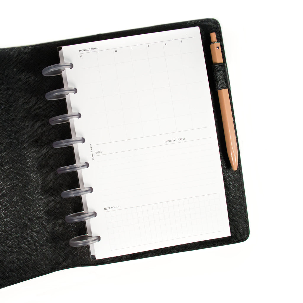 Monthly Admin Planner Inserts styled inside a discbound planner in a black leather cover. 