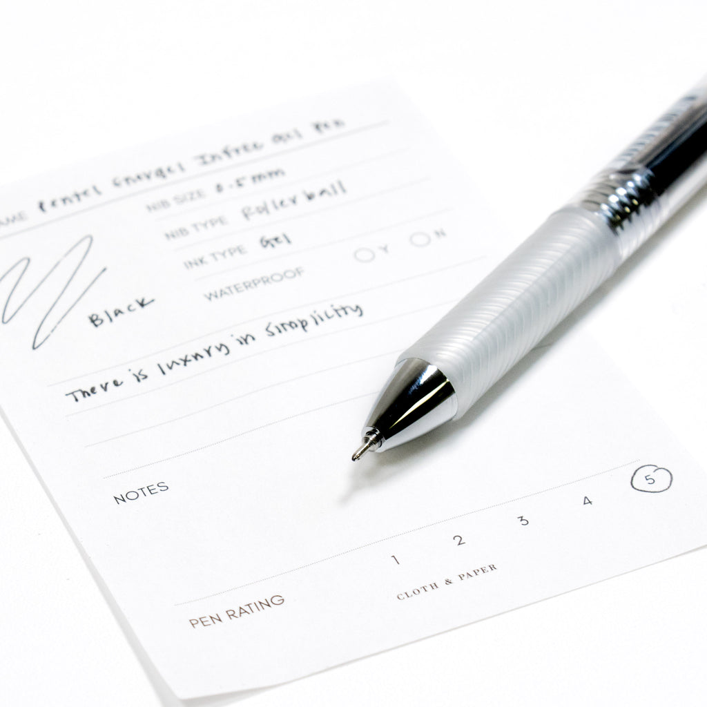 Pentel Energel Infree Gel Pen, Black, Cloth and Paper. Close up on pen nib resting on pen test sheet.