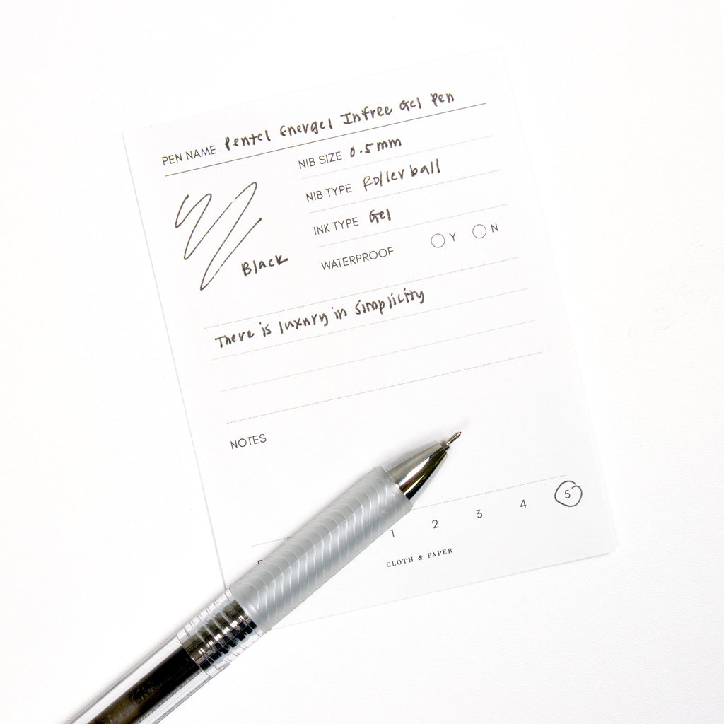 Pentel Energel Infree Gel Pen, Black, Cloth and Paper. Pen resting on pen test sheet displaying writing sample.