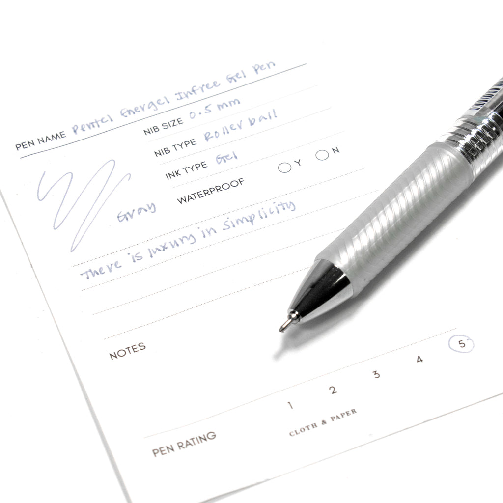 Pentel Energel Infree Gel Pen, Gray, Cloth and Paper. Pen resting on pen test sheet displaying writing sample.