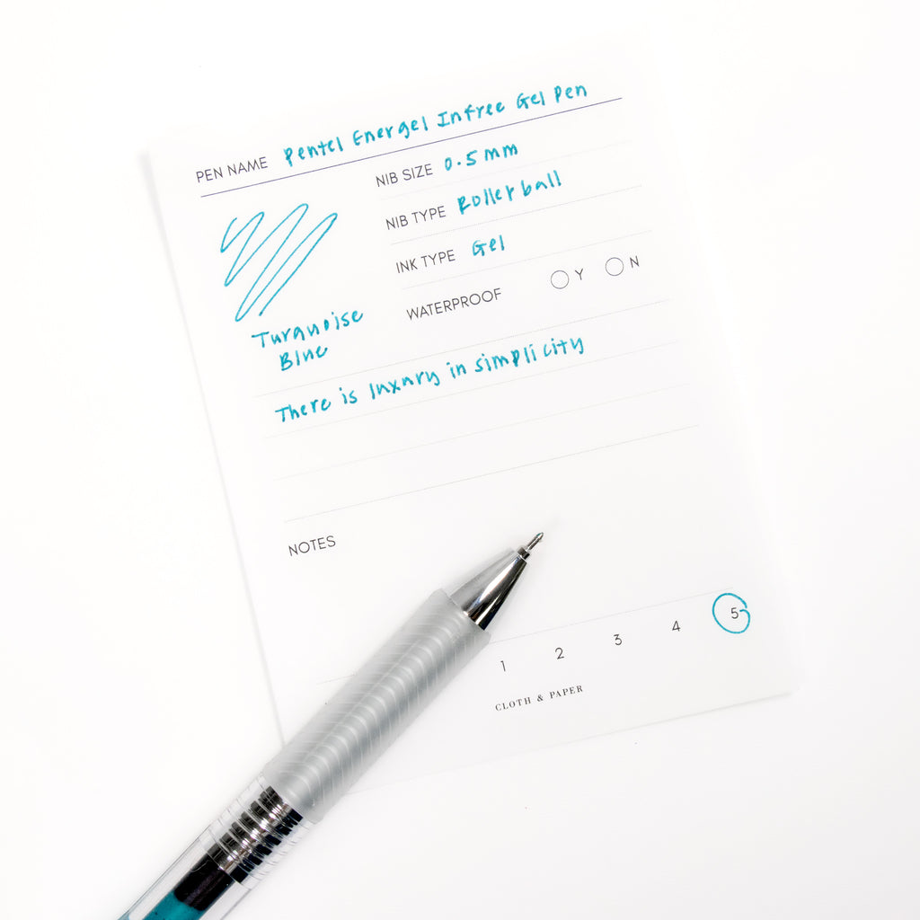 Pentel Energel Infree Gel Pen, Turquoise-Blue, Cloth and Paper. Close up on pen nib resting on pen test sheet.