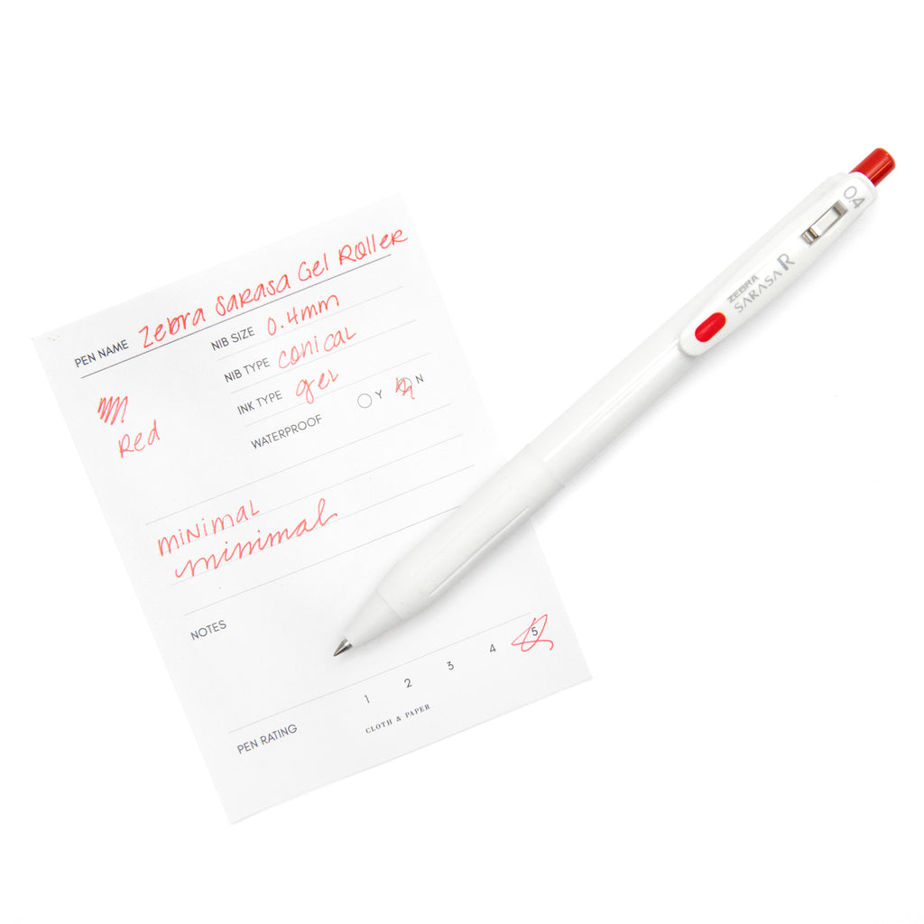 Zebra Sarasa R Pen, 0.4 mm, Red, Cloth and Paper. Pen resting on pen test sheet displaying writing sample.